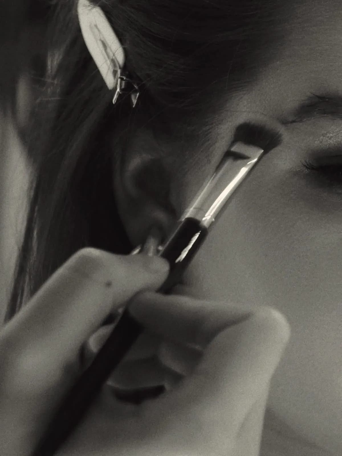Black-and-white close-up of a brush blending along the eye