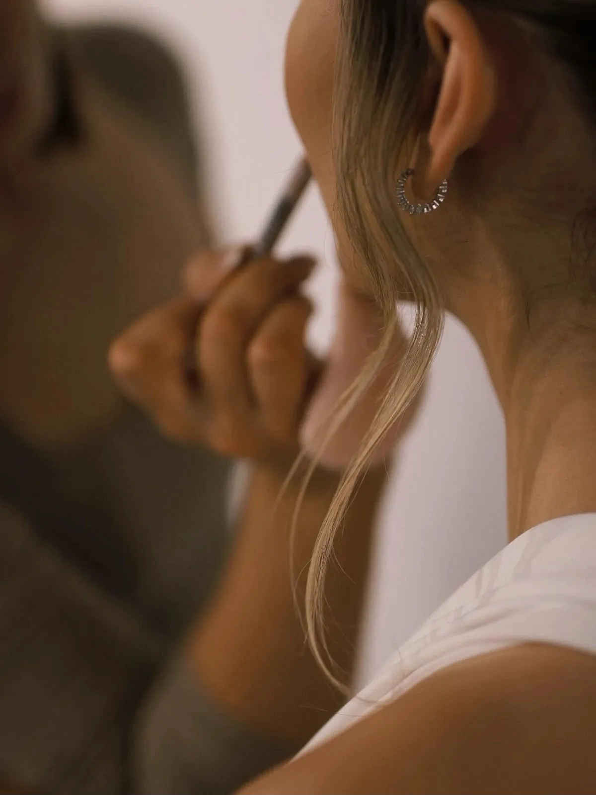 Warm-lit moment of a look being applied