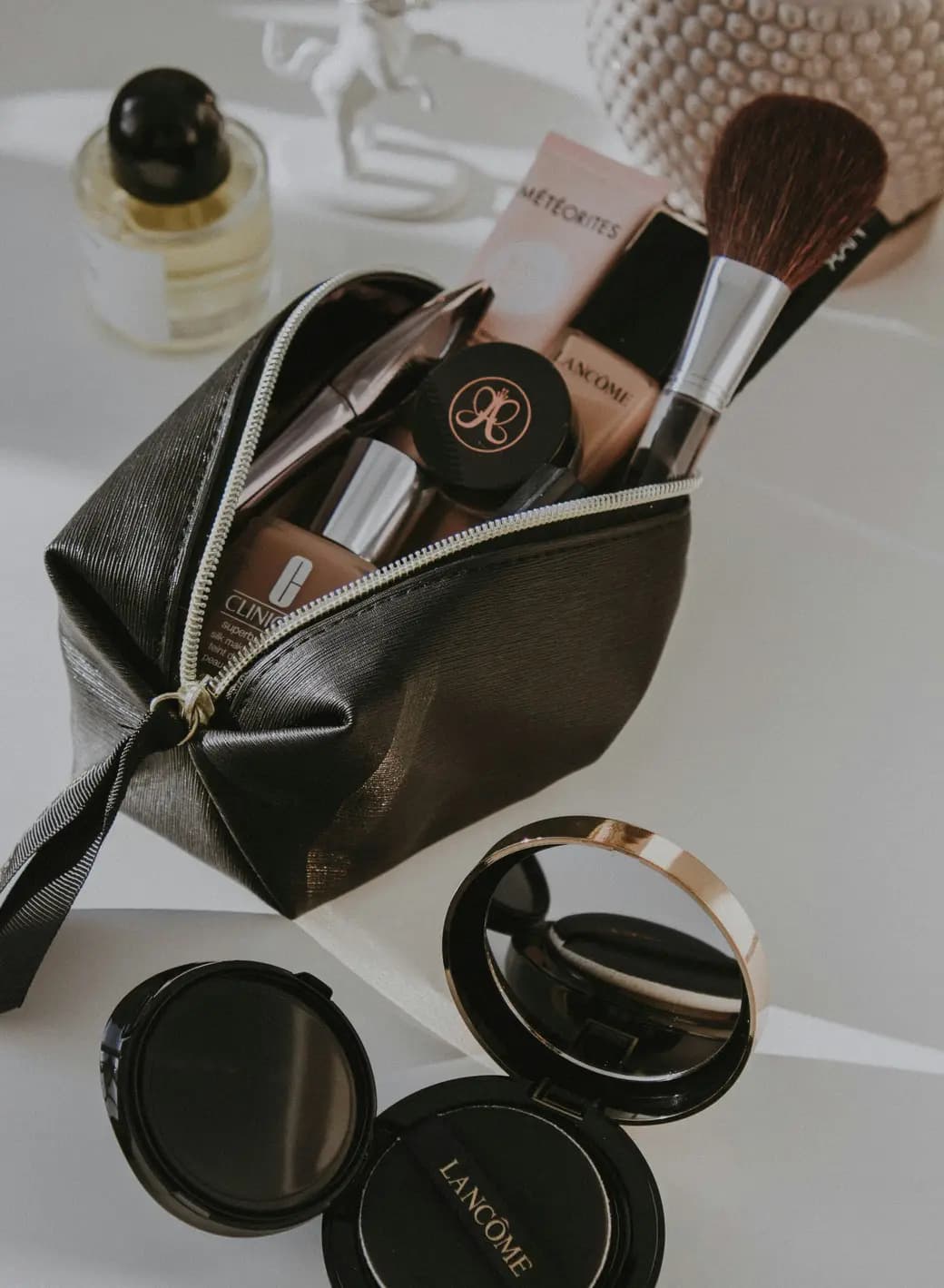 Makeup pouch with foundation, a powder brush and compacts