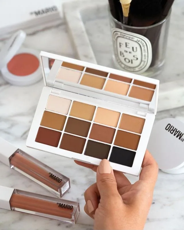 Neutral matte palette and lip glosses styled on marble